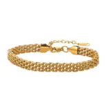 Gold and silver stainless steel chain braided bracelet flat lay on white