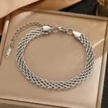 Silver stainless steel chain braided bracelet displayed in a box