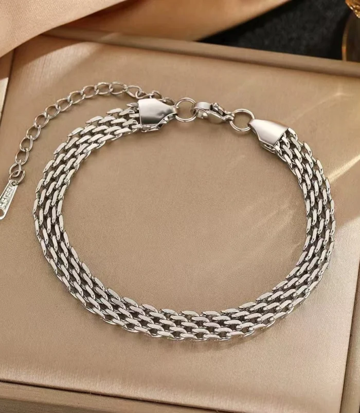Silver stainless steel chain braided bracelet displayed in a box