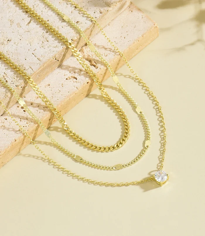 gold-and-silver-layered-zircon-pendant-necklace-6 Gold and silver layered zircon pendant necklace laid flat on stone display