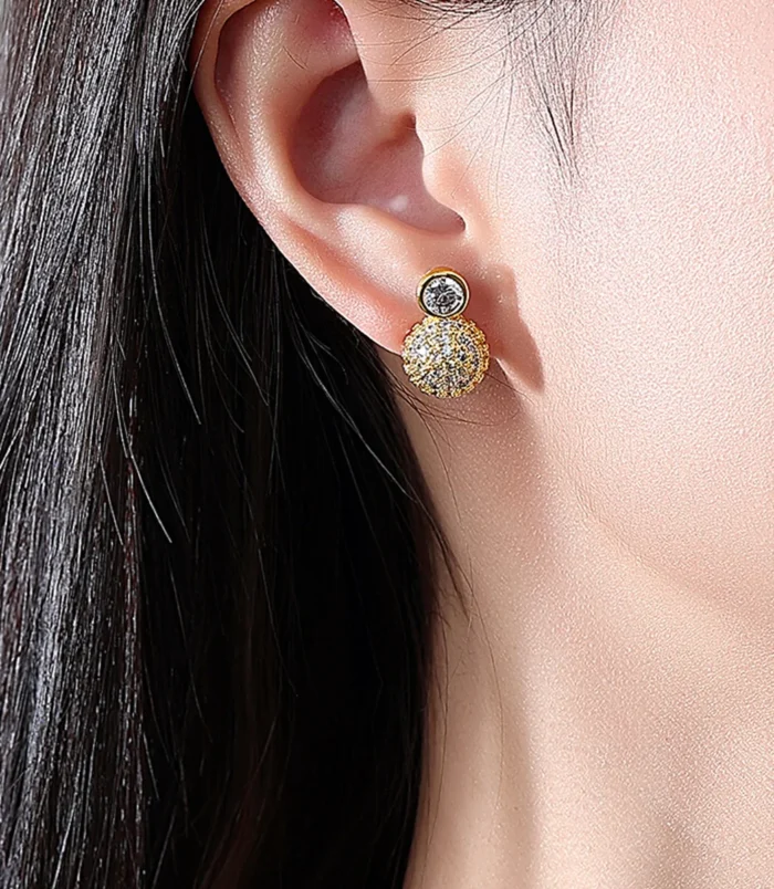 Gold & Silver Zircon Stud Earrings worn securely on a woman's earlobe.