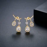Gold & Silver Zircon Water Drop Earrings in gold close-up on a dark display.