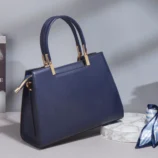 Multicolor PU leather Boston bag back view with the decorative scarf placed beside it.