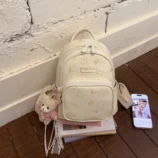 Pastel Cat Print PU Leather Backpack for Women white version resting on books.