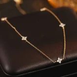 Silver and Gold Minimalist Rhinestone Necklace for Women in a close-up view on a dark leather display.