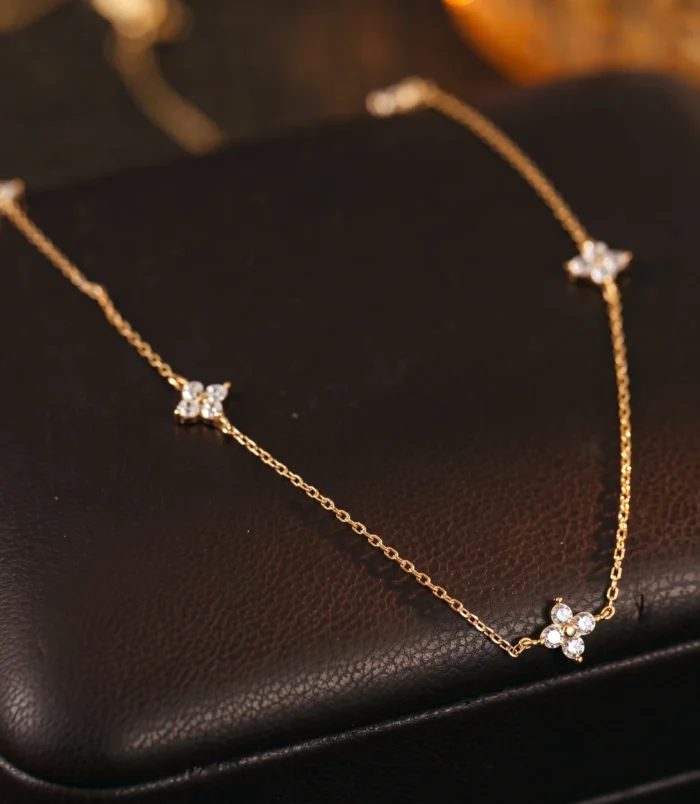 Silver and Gold Minimalist Rhinestone Necklace for Women in a close-up view on a dark leather display.