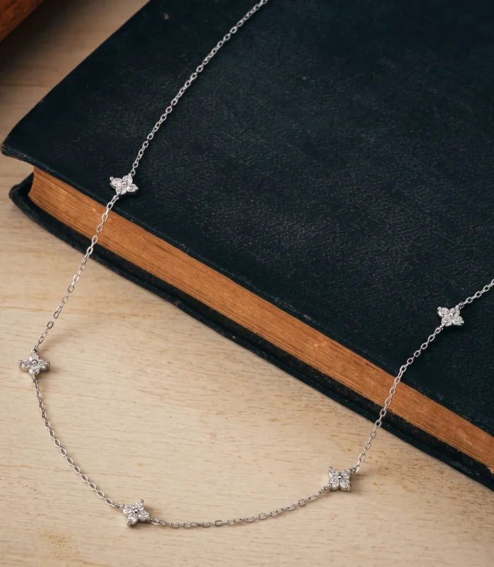A beautifully crafted silver minimalist rhinestone necklace resting on a dark surface.