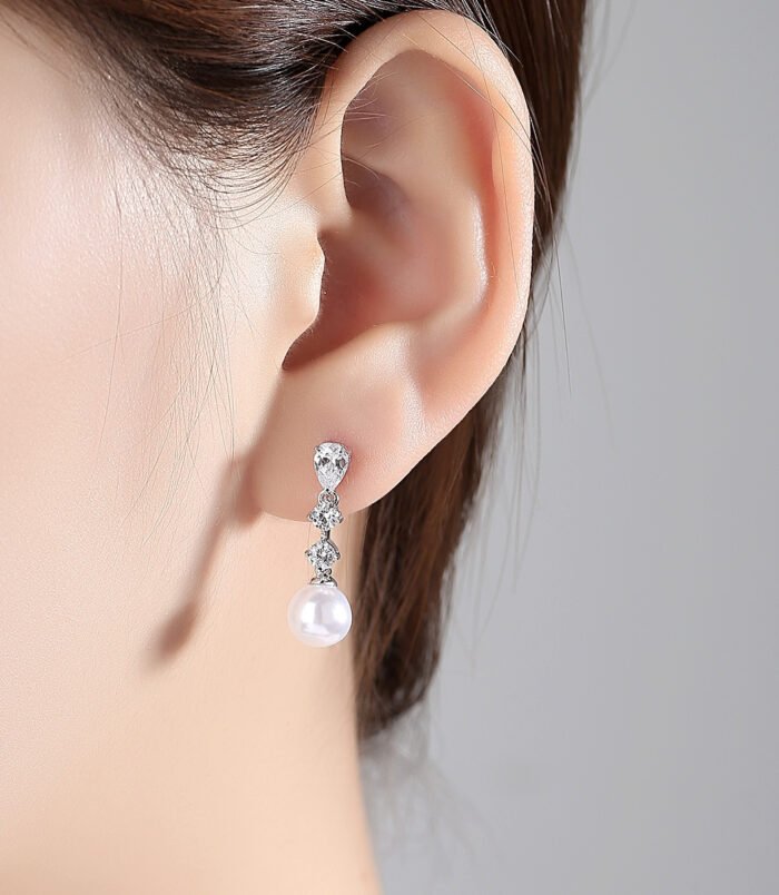 Silver-Plated Zircon Pearl Drop Earrings for Women standing on a dark surface highlighting the shine.