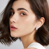 Silver zircon earrings for women displayed frontally against a black background