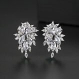 Silver zircon earrings for women worn on the ear by a model looking back
