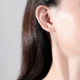 Sterling silver leaf earrings worn on the earlobe by a model.