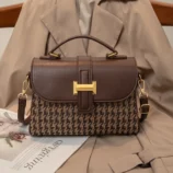 Elegant brown vintage houndstooth handbag with a gold buckle front view.
