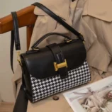 Black and Brown Vintage Houndstooth Handbag for Women - black bag side angle resting on chair.