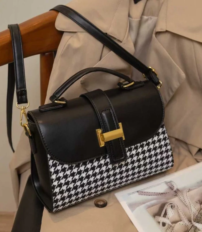 Black and Brown Vintage Houndstooth Handbag for Women - black bag side angle resting on chair.