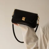 Stylish black PU leather baguette bag worn elegantly on the shoulder.