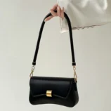 Black & White PU Leather Baguette Bag for Women held by hand showing the shoulder strap.