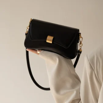 Stylish black PU leather baguette bag worn elegantly on the shoulder.
