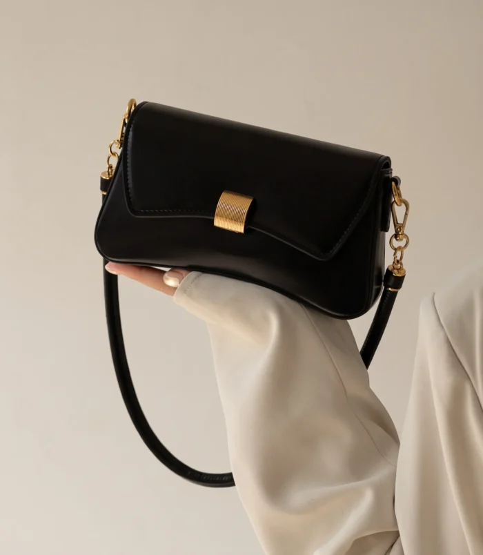 Stylish black PU leather baguette bag worn elegantly on the shoulder.