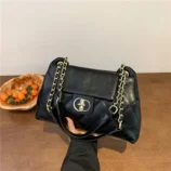 Black & White Quilted PU Shoulder Bag held by hand displaying soft PU leather