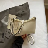 Casual PU leather hobo bag in creamy white held against a blazer