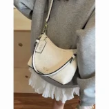 White crossbody bag worn comfortably over the shoulder with casual attire