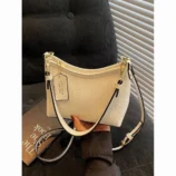White commuter purse resting elegantly on top of a book