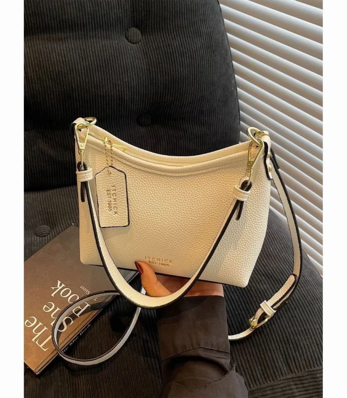 White commuter purse resting elegantly on top of a book