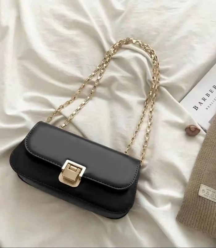 Classic PU Leather Underarm Bag for Women in black resting on a bed