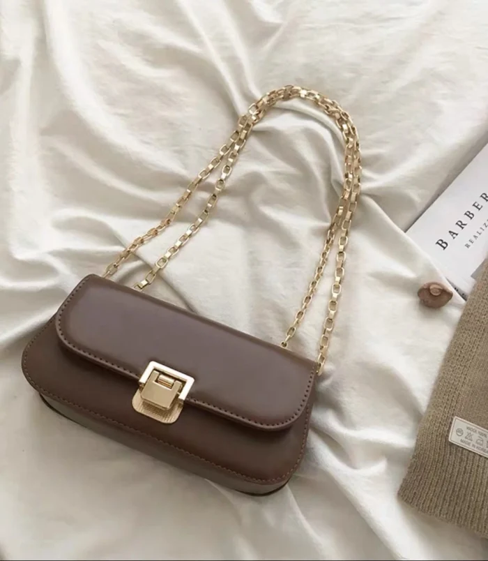 Classic PU Leather Underarm Bag for Women in brown styled with a book