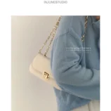 Classic PU Leather Underarm Bag for Women in white styled with a blue sweater
