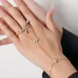Gold zircon flower finger bracelet worn elegantly on a woman's hand.