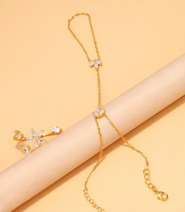 Elegant zircon flower finger bracelet styled elegantly over a beige display roll.