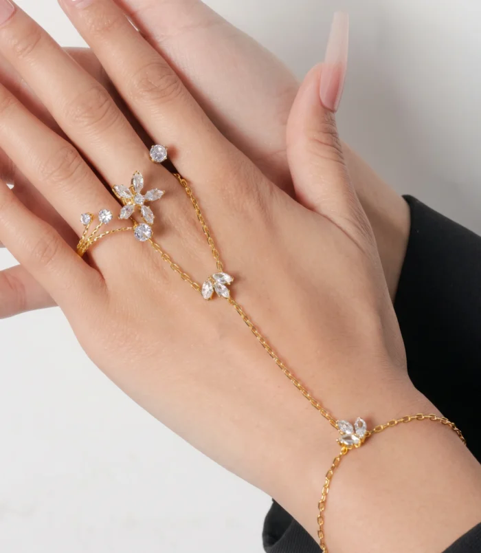 Gold zircon flower finger bracelet worn elegantly on a woman's hand.