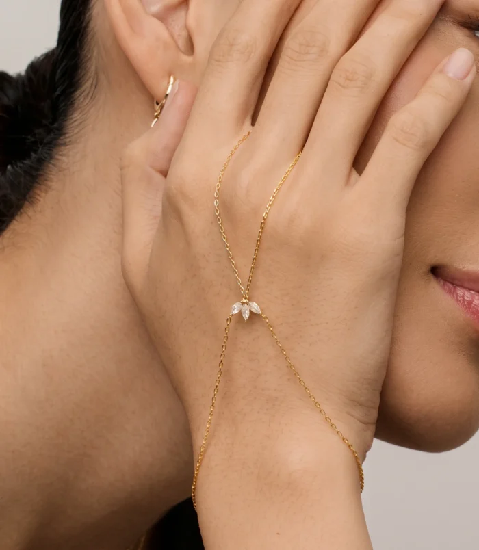 Elegant gold leaf finger bracelet worn gracefully on a woman's hand.