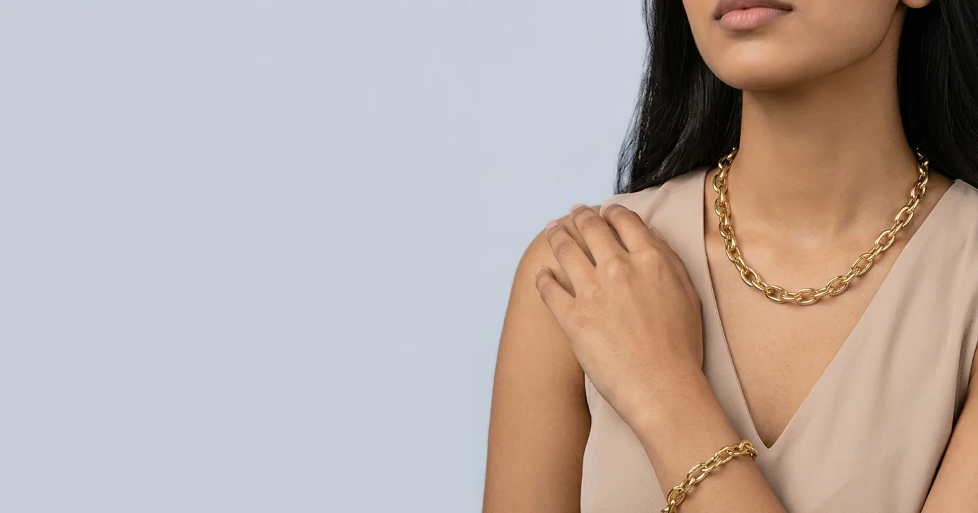 Woman wearing a bold gold chain necklace and matching chain bracelet
