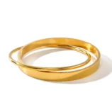 Gold Double Loop Bracelet in Stainless Steel placed flat on a clean white surface.