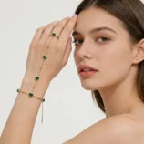 Elegant gold-plated heart finger bracelet worn gently on a model's hand