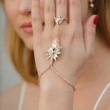 Elegant rhinestone leaf finger bracelet worn on a woman's hand.
