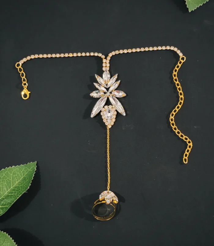 Gold & Silver Rhinestone Leaf Finger Bracelet gold flat lay view on dark background.