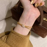 Elegant gold wire wrapped bracelet worn gracefully on a woman's wrist.