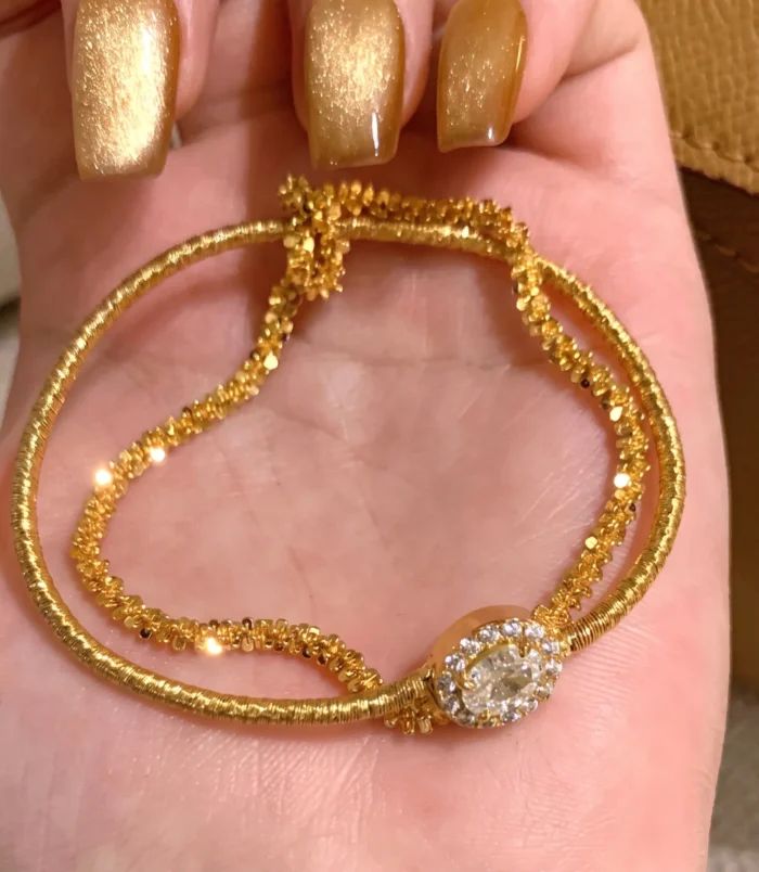 Gold & Silver Wire Wrapped Bracelet displayed in hand showing close-up golden texture.