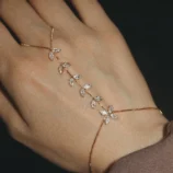 Elegant gold zircon finger bracelet worn on a woman's hand.