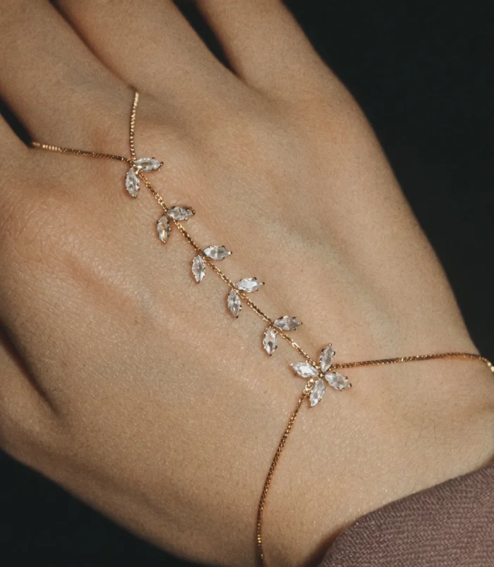Elegant gold zircon finger bracelet worn on a woman's hand.