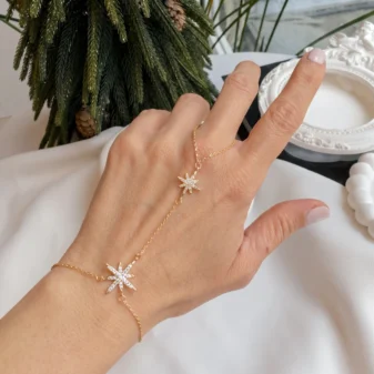 Gold star rhinestone finger bracelet worn on hand with sparkling crystal charms