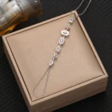Silver white diamond variant of the finger bracelet displayed on a gift box