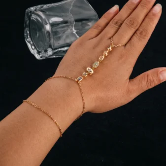 Elegant gold titanium steel finger bracelet worn on hand showing sparkling stone details