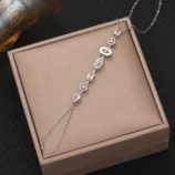 Silver pink diamond variant of the finger bracelet showcased on a presentation box