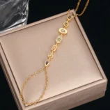 Golden colored diamond variant of the finger bracelet on a beige background