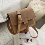 Multicolour PU leather square crossbody bag resting on hand in khaki