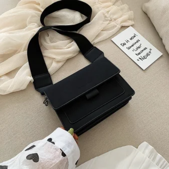 Multicolour PU leather square crossbody bag resting on hand in black